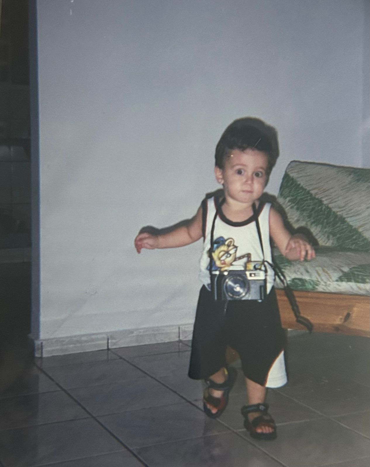 Foto de infância do Garça caminhando com uma câmera pendurada no pescoço